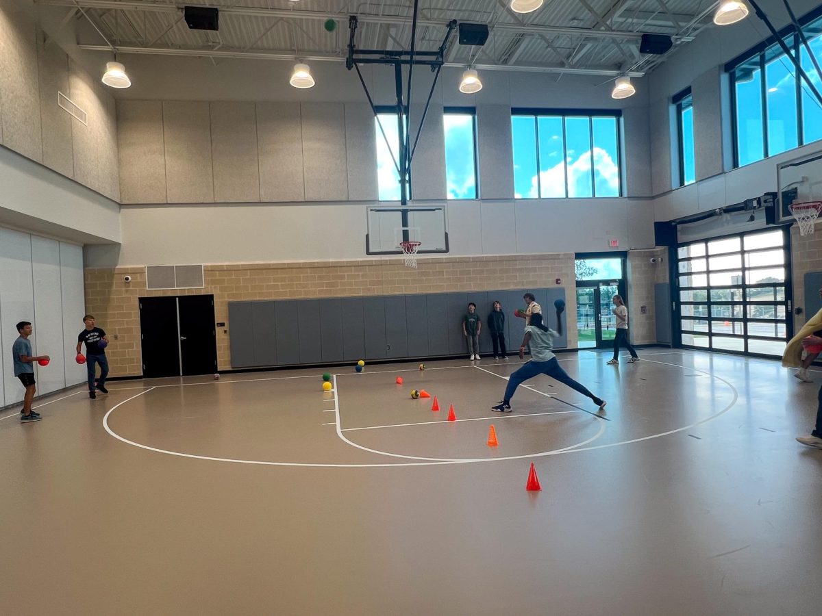 Preston Morgan, Oliver Goodman, Zander Abolos, Aedan Robertson, Aydin Evans, Ben Corson, and Oluwaseun Olufemi playing dodgeball in the brand new gym. 