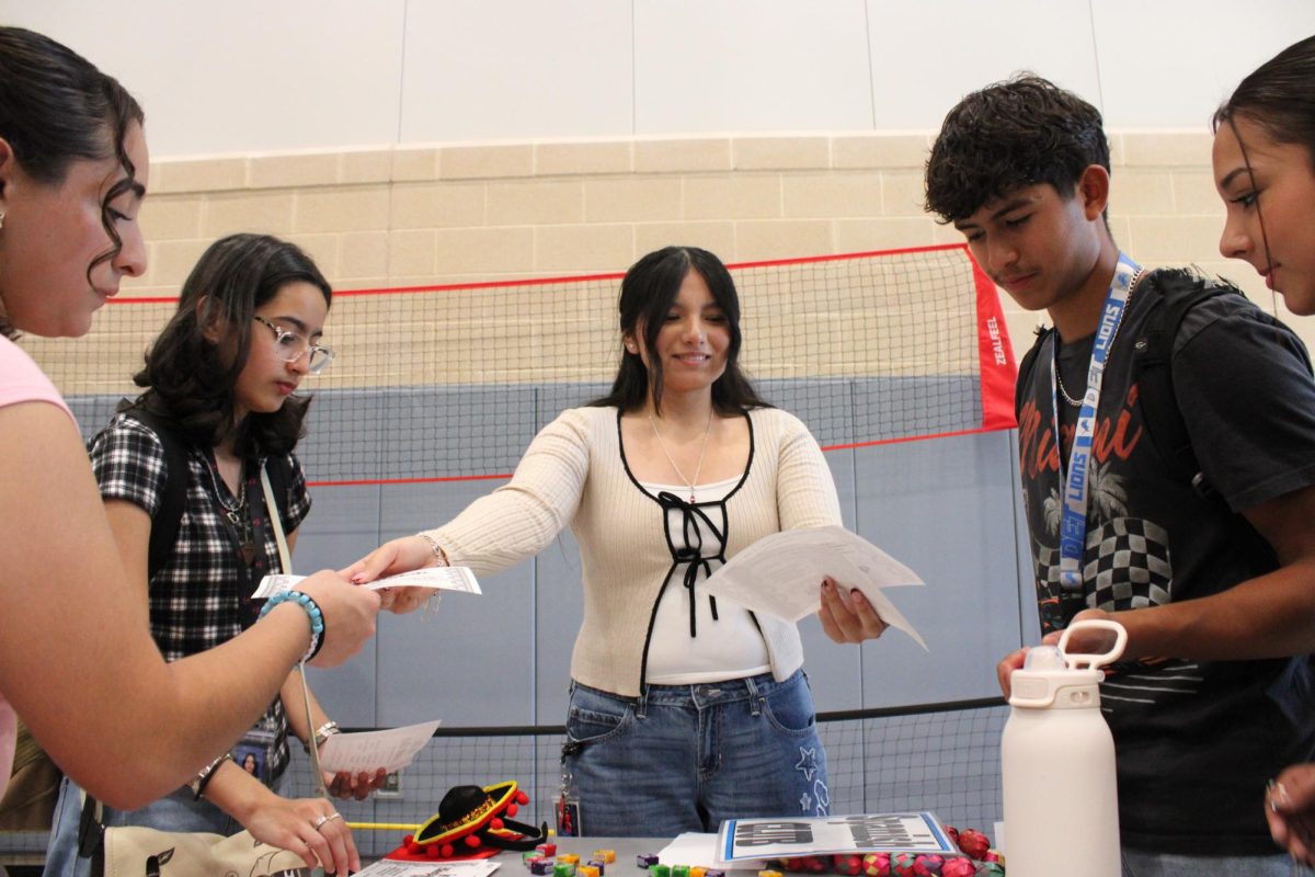 Senior Marisol Aguilar handing out flyers for the Spanish Club at the club fair.