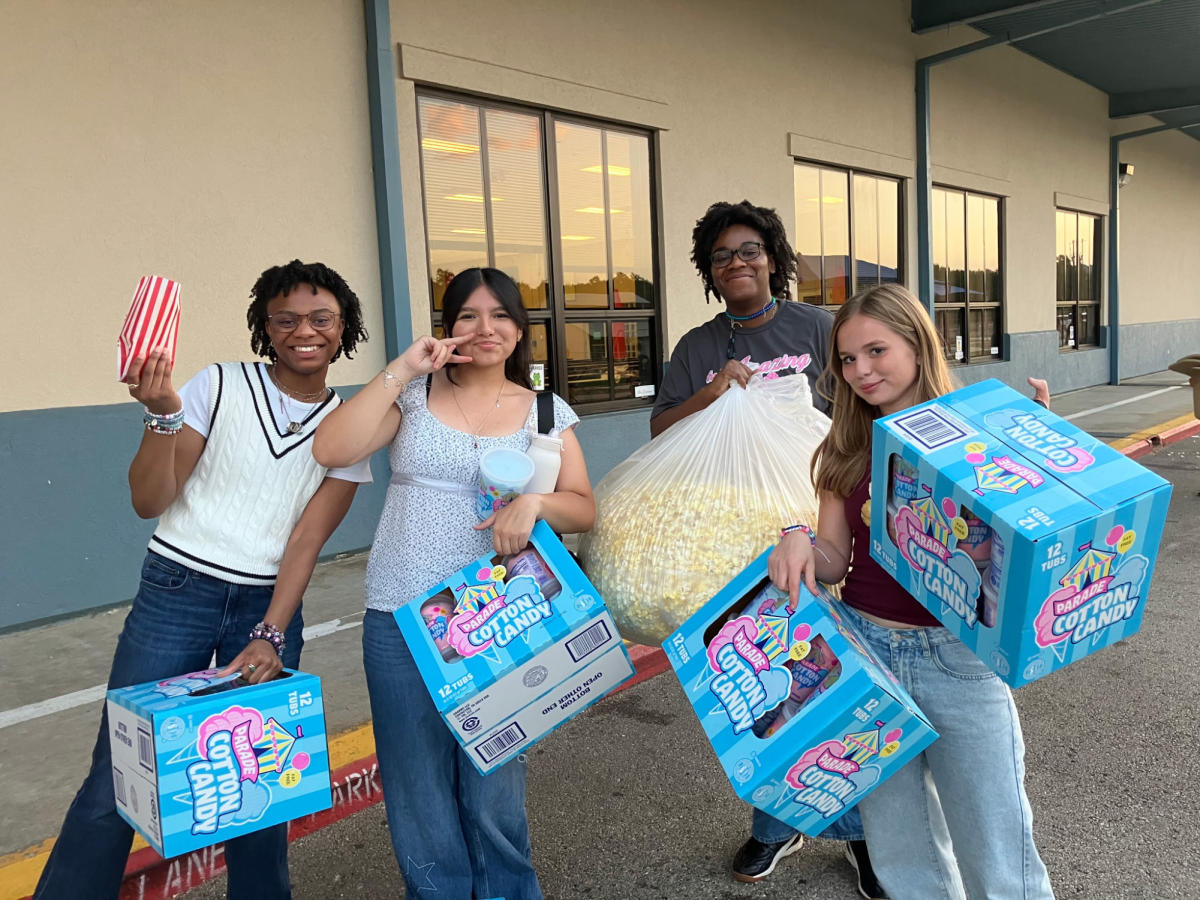 Sophomore Aiyanah Payton and seniors Marisol Aguilar, Aurieanah Payton and Kylie McCranie smile with their haul from the Bill Brown Fall Festival. The students volunteered and in an attempt to avoid tossing perfectly good food, the PTSA at Bill Brown gave the girls the left over supplies at the end of the night. Photo courtesy of Payton.