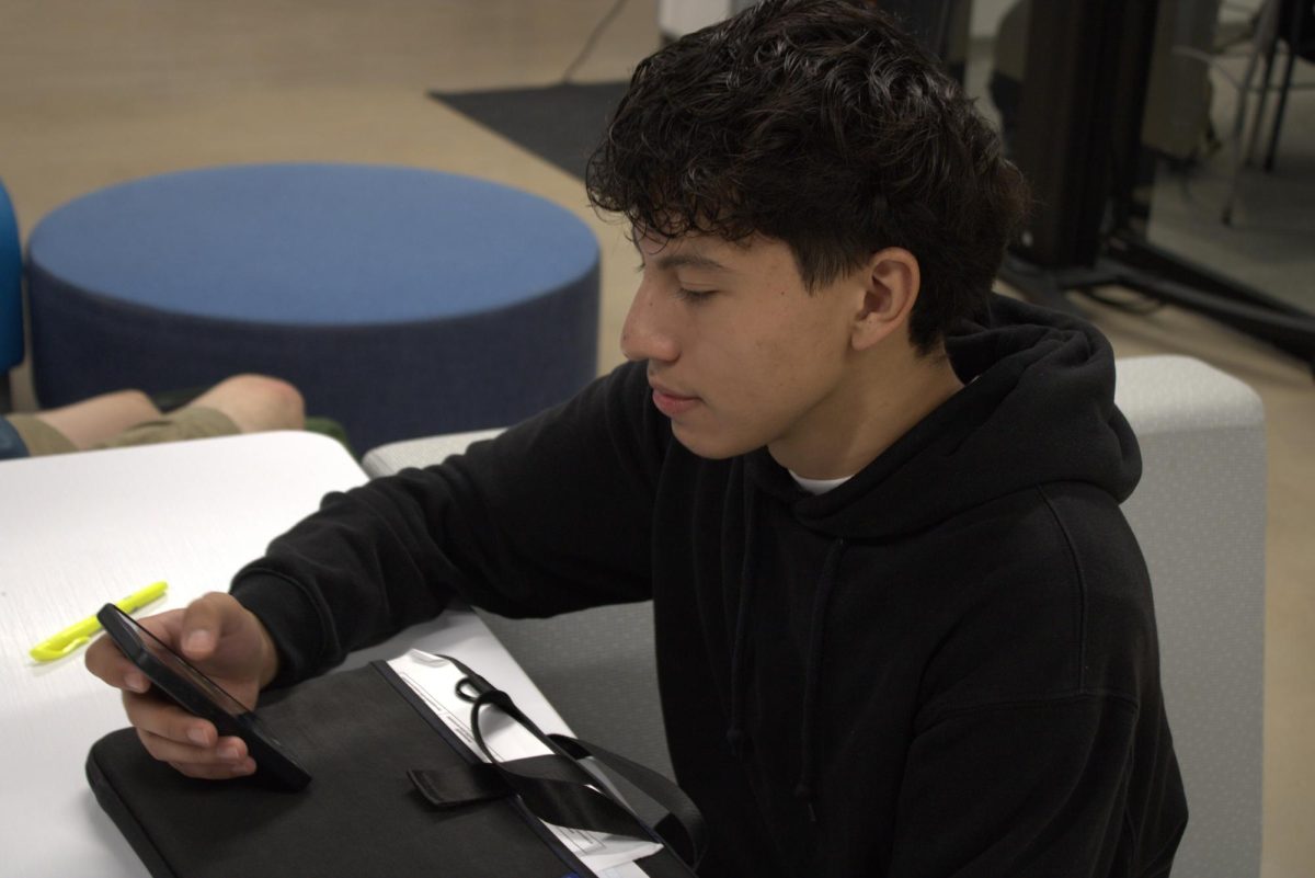 Junior Emmanuel Carranza using his phone to play games before school starts. With the new phone ban, students can only use their phone in the mornings before school and in the afternoons after school.