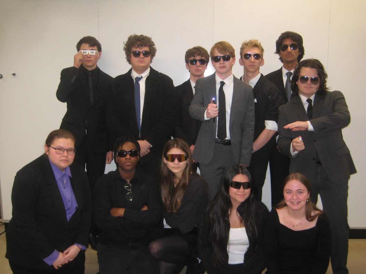 Seniors Breck Leon, Benjamin Corson, Luke RInglein, Eric Barnard, Kai Anderson, Keshav Singh, Donovan Dayley, Annabelle McKee, Brianna Schmeis, Isabella Villarreal, Aurieanah Payton and Emerson Fite celevrating their senior shenanigan by dressing up as Men in Black.