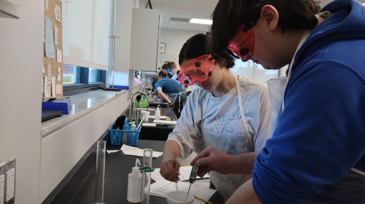 Sophomore Abigail Gibson and Jake Giglio in Pre-AP Chemistry performing a lab to further explore Hess' law. Photo by Kylie Trexler