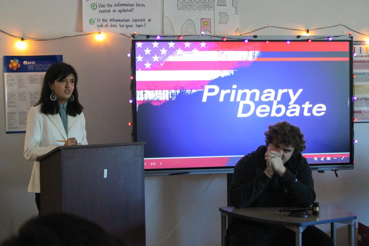 Seniors Michelle Linares-Moreno and Benjamin Corson acting as candidate and moderator respectively during the primary debate for their project in AP Government. Photo by Kylie Trexler